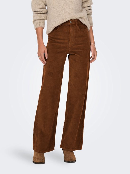 Model in bruine corduroy broek met wijde pijpen en beige trui.