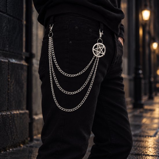 Zilverkleurige broekketting met drie lagen en pentagramhanger bevestigd aan een zwarte spijkerbroek.