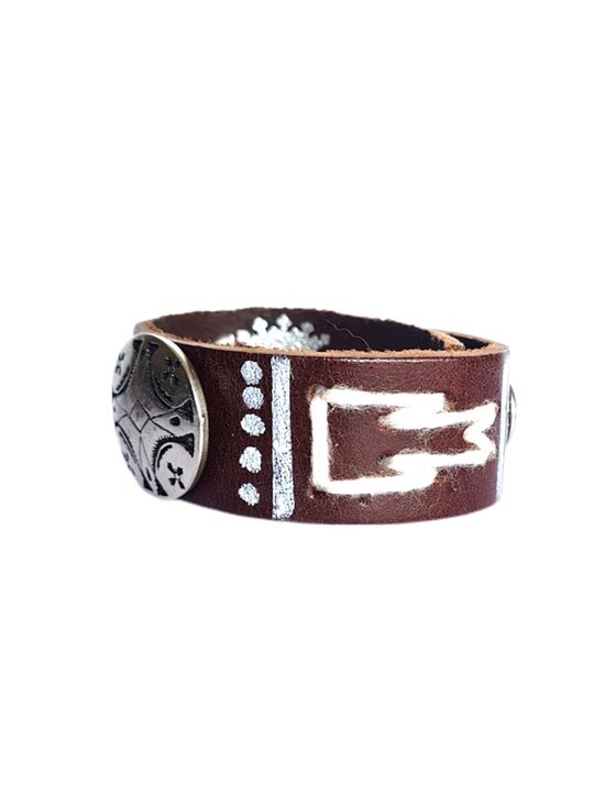 Bruin lederen armband met zilverkleurige studs en witte decoraties.