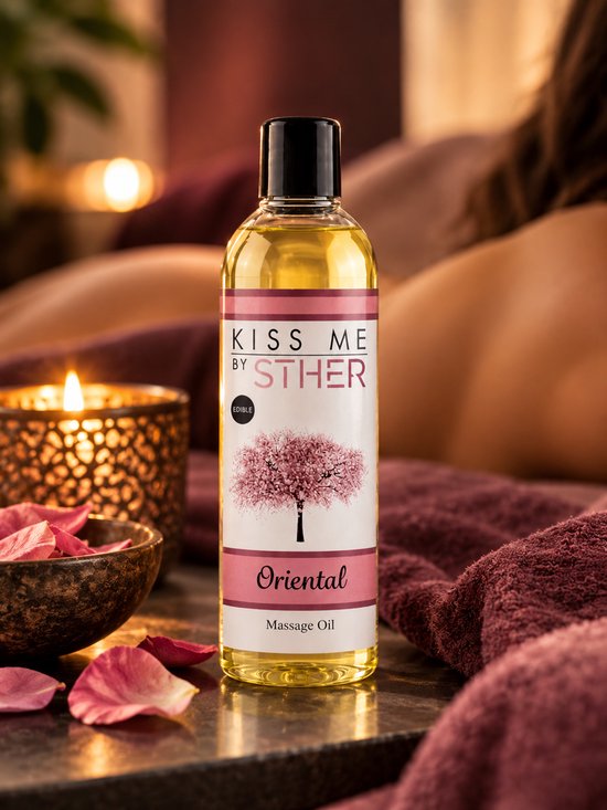 Fles 'Oriental' massageolie van Sther op een donkere steen, met handdoek, bloemblaadjes en kaarslicht. Met bloeiende kersenboomillustratie.