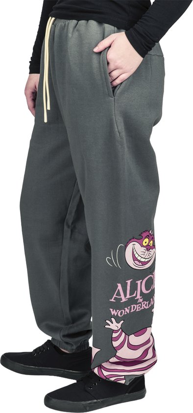 Grijze joggingbroek aan de zijkant, met Cheshire Cat-afbeelding en Alice in Wonderland-tekst.