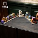 LEGO Wegisweg set, bestaande uit drie delen, op een donkere houten tafel: links met paarse bus, midden met witte toren, rechts met winkels.