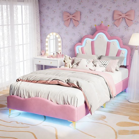 Roze kinderbed met kroonvormig hoofdbord met LED-verlichting, in een slaapkamer met roze strikken en een kaptafel.