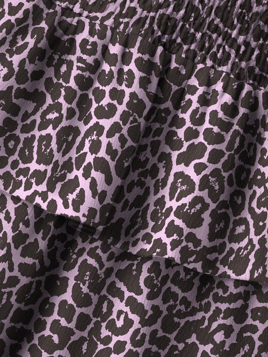 Close-up van een roze stof met een zwart luipaardpatroon en een gelaagd ontwerp.