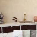 Keuken aanrecht met drie zakjes supplementen voorin. Koffiezetapparaat en spoelbak op de achtergrond.