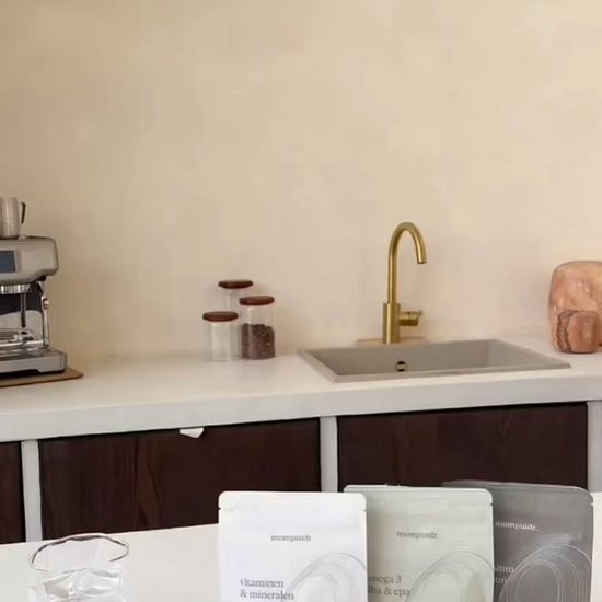 Keuken aanrecht met drie zakjes supplementen voorin. Koffiezetapparaat en spoelbak op de achtergrond.