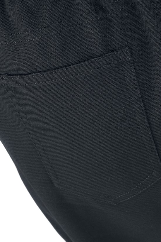 Close-up van de achterkant van een donkergrijze broek, focus op de rechthoekige achterzak.