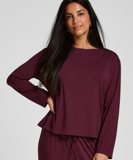 Model draagt een paarse pyjamatop met lange mouwen en een bijpassende broek.