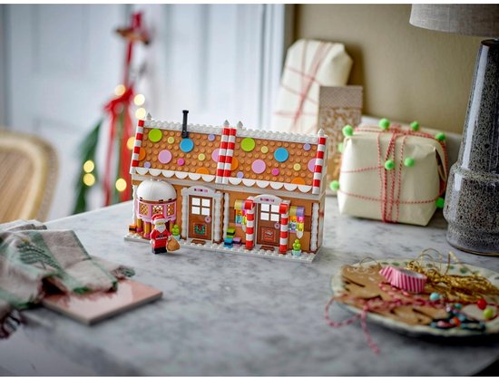 LEGO winters peperkoekhuis op een marmeren aanrecht met cadeau's en decoraties.