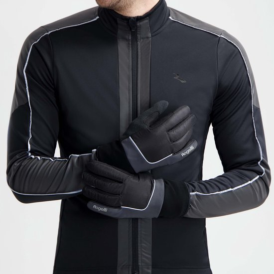 Model draagt zwarte Rogelli fietshandschoenen met reflecterende accenten en een bijpassend zwart sportjack.