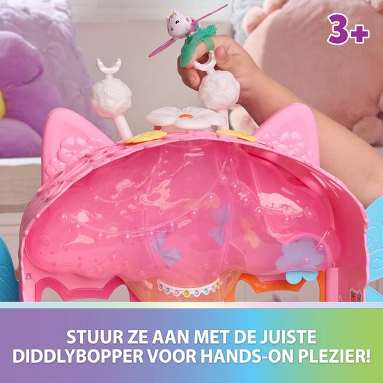 Hand plaatst een speelgoedfee op een roze poppenhuis. Tekst: Stuur ze aan met de juiste Diddlybopper voor hands-on plezier!