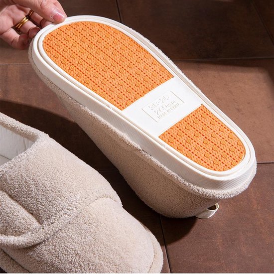 Onderkant van een beige pantoffel met een oranje antislipzool, inclusief maatlabel 38-39.