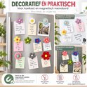 Bloemmagneten op een koelkast en memobord met tekst zoals 'Decoratief én praktisch'.