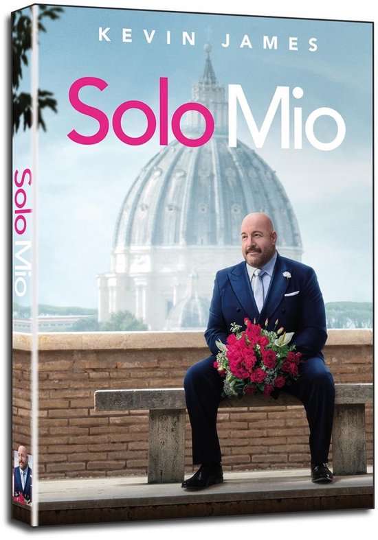 Kevin James en costume bleu avec un bouquet de roses rouges sur un banc devant le dôme du Vatican. Texte : Solo Mio.