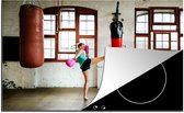 KitchenYeah® Inductie beschermer 76x51.5 cm - Een Thaise bokser doet een high kick in een fitnessruimte - Kookplaataccessoires - Afdekplaat voor kookplaat - Inductiebeschermer - Inductiemat - Inductieplaat mat