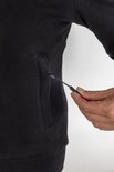 Zijzak van zwarte hoodie waar een koord uitkomt, gebruikt voor de powerbank.