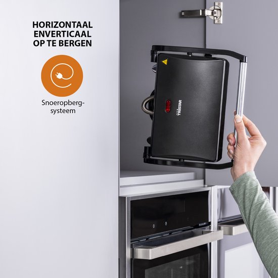 Vrouw bergt zwarte Tristar contactgrill verticaal op in keukenkastje.