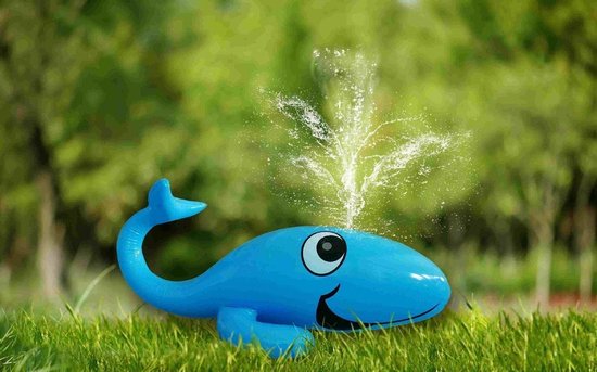 Blauwe opblaasbare walvis fontein met spuitend water, op groen gras.