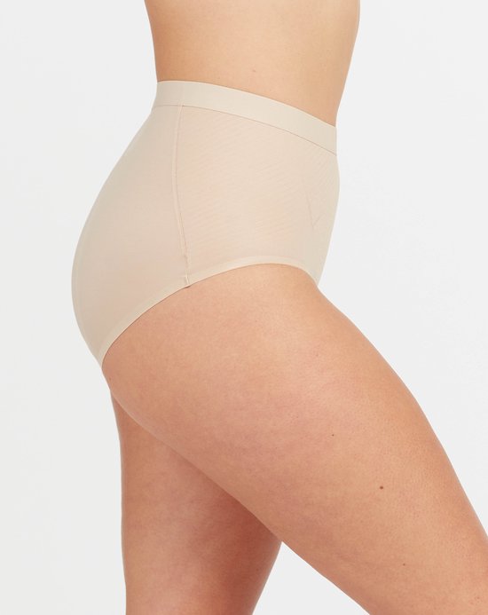 Nude hoge bikinislip, van de zijkant gezien, met textuur en verstevigende inzetstukken.