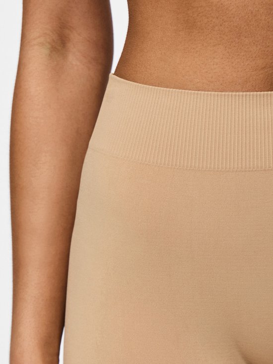 Close-up van de tailleband van een beige, naadloze fietsshort.