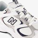 Close-up van de witte New Balance 408 sneaker, met details van de witte veters, de marineblauwe en grijze accenten en het 'N' logo.