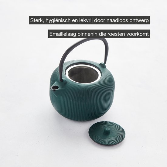 Donkergroene geribbelde gietijzeren theepot, open met een zilveren thee-ei en deksel ernaast. Interne emaillelaag zichtbaar.