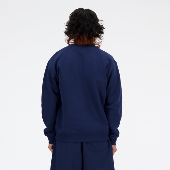 Man draagt donkerblauwe New Balance trui met wit logo, van achteren gezien.