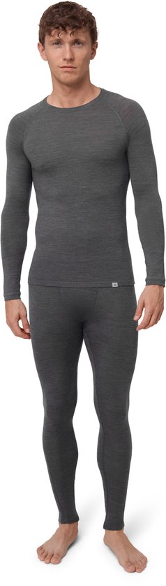 Man staat in het midden, gekleed in een donkergrijs, langslapend thermoset en een bijpassende lange broek.