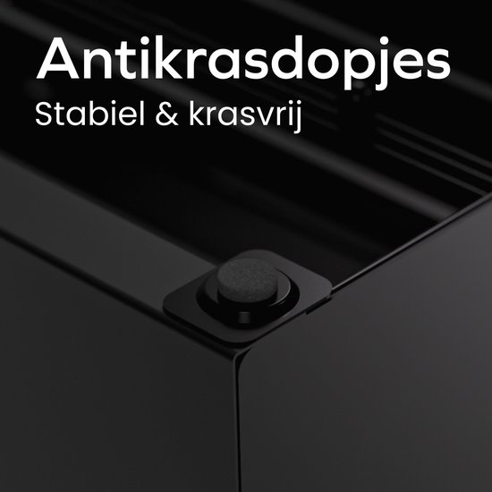 Détail des pieds antidérapants sous un porte-capsules noir.