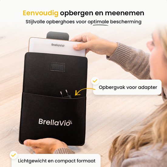Vrouw doet de daglichtlamp met bruine rand in een zwarte opberghoes met een vakje voor de adapter.