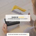 Handen openen een witte doos met een zwarte draagcase met 'BrellaVio' erop. Tekst: Bekijk de reviews.