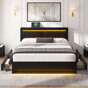 Zwart gestoffeerd bed met LED-verlichting, USB-poort en vier opberglades. Gevuld met een grijze deken en kussens.