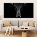 Œuvre d'art noir et blanc d'une tête de taureau aux cornes imposantes, présentée dans un salon.