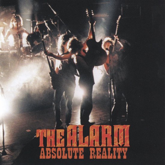Albumcover van The Alarm - Absolute Reality met de bandleden op het podium in gedimd licht.