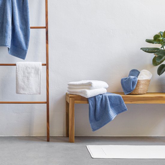 Blauwe en witte handdoeken op een houten ladder en bank.
