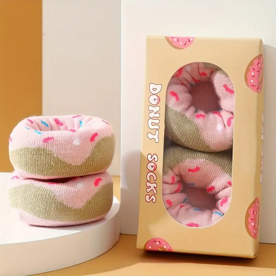 Roze sokken met donutprint en roze & blauwe spikkels. De sokken hebben een groene band en zijn opgerold als donuts.