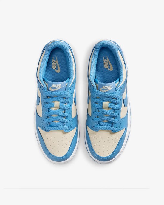 Bovenkant van een paar Nike Dunk Low sneakers in crème en lichtblauw leer met blauwe veters.