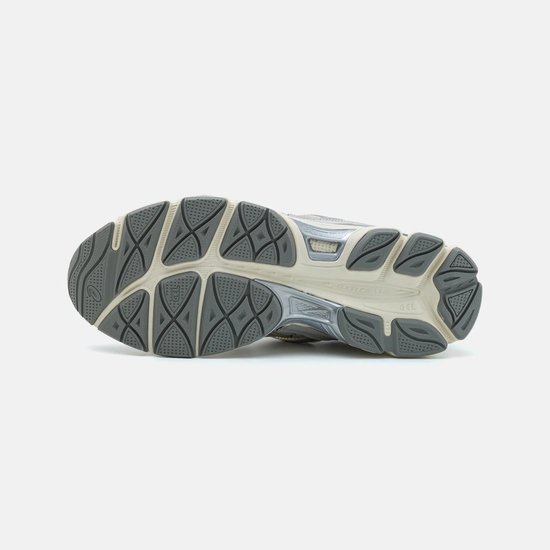 Onderkant van grijze ASICS sneakers met beige zool en complex patroon.