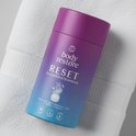Body Restore RESET Shower Steamers in paars-blauwe cilinder op een witte handdoek.