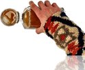 Een hand in een gebreide trui met patroon, die een glazen karaf met amberkleurige vloeistof en ijsklontjes vasthoudt.