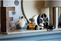 Figurines LEGO WALL-E, EVE et petit robot sur une cheminée avec des bobines de film.