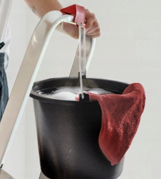 Vrouw vult een emmer met water met behulp van de rode haak van de aluminium ladder.