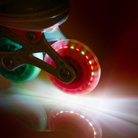 Close-up van een lichtgevend roze wiel van een skeeler.