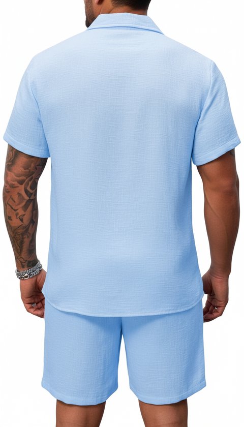 Man, achterkant, draagt lichtblauwe korte mouw blouse en korte broek. Blouse met structuur.