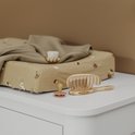Zandkleurige aankleedkussenhoes met bosdierenprint, met kleding en babysetting.