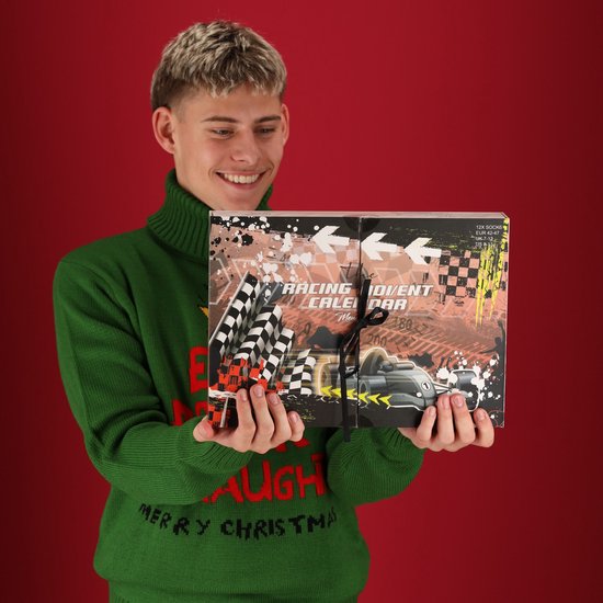 Jeune homme aux cheveux blonds portant un pull vert à col roulé, tenant un calendrier de l'avent de course.
