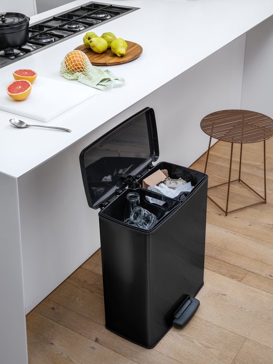 Zwarte Curver Deco Bin in een keuken met twee open compartimenten gevuld met afval.