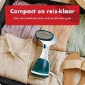 Witte en turquoise handstomer in een koffer met opgevouwen kleding. Tekst: "Compact en reis-klaar". Afmetingen 23 cm en 13 cm.