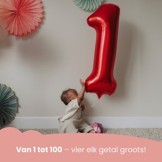 Baby reikt naar grote rode cijfer 1 ballon