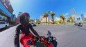 Motorrijder in rode helm en zwarte outfit rijdt op een rode motorfiets in Las Vegas.